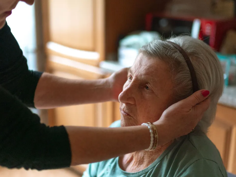 Caregiver attending to a senior woman at home